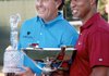 Phil Mickelson and Tiger Woods hold the trophies for winning the Tour Championship and FedEx Cup, respectively.