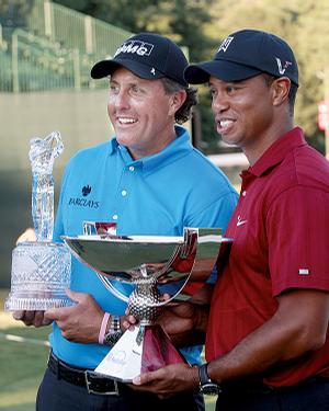 Phil Mickelson and Tiger Woods hold the trophies for winning the Tour Championship and FedEx Cup, respectively.