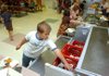 Third-grader Josh Dubois grabs a milk carton Monday during lunch at Root Elementary School in Fayetteville. A few area school districts have prohibited allowing students to eat now and pay later when their lunch balances dwindle because the schools could be treated like creditors under federal law. 