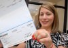Delina (cq) Snow of Van Buren holds a check for $15,000 (the net amount) on Tuesday afternoon at the Arkansas Lottery Claims Center in downtown Little Rock. 