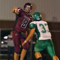 Lincoln quarterback Zach Summers (9) throws the ball away before being tackled by Greenland's Jeremy...