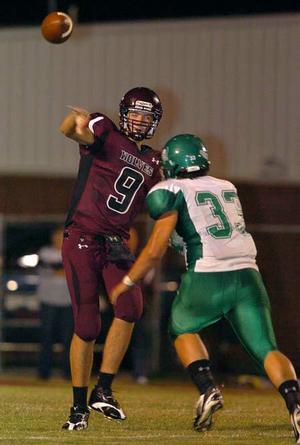 Lincoln quarterback Zach Summers (9) throws the ball away before being tackled by Greenland's Jeremy Huber (33) during play at Lincoln, Sept. 25. 
