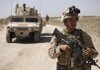 U.S. Marine radio operator and infantryman Lance Cpl. Walter Jennings of Normal, Ill., walks in front of an armored vehicle Monday in Nawa district, Helmand province, southern Afghanistan.