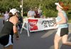 Julie Brooks (right) crosses the finish line of the 2008 Wiggins Cabin Festival
5K at Crossett while Melissa Brown (left) encourages her.