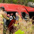 <b>Wet-weather rollover</b>
Emergency personnel worked to extricate a victim from an overturned For...
