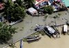 Outriggers are seen beside houses that serve as their residents' means of transportation as streets remained flooded Monday in the town of Angono, Philippines.