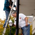 Boyd Goettsch (left) and Julie Dalton paint poles supporting the awning of West Mountain Brewing on ...