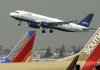 A JetBlue Airbus flies over a pair of Southwest Airlines jets at Bob Hope Airport in Burbank, Calif., in this file photo.