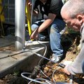 Drew Cardillo, left, and Mark Gross, with Monitronics Monitored Security Systems, installed security...