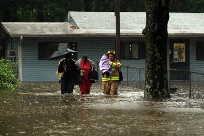 little-rock-firefighter-william-bowden-carries-a-small-child-through-knee-high-water-friday-as-the-final-two-employees-leave-the-dreamland-child-development-center