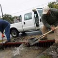 Alfred DeRoche (right) and Brad Robbins with the Fayetteville Transportation Department clear debris...