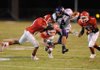 Fayetteville senior receiver Michael Heintzman (4) leaps to avoid Fort Smith Northside senior Salih Willis, left, as seniors Zach Morehart (28) and James Jackson close in on the play during the first quarter of play Friday at Mayo-Thompson Stadium in Fort Smith.