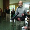 Photographer Steve Moore smiles as Fayetteville Public Library Executive Director Louise Schaper han...