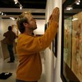 Adam Campbell of Fayetteville hangs art work Friday at the new University of Arkansas Student Galler...