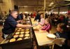 Capt. Willie Watts with the Fayetteville Fire Department, left, serves pancakes to Skyler Autry, 10, as friends McKenzie Selph, 10, right, and Shelby Dockery, 12, make their way through the line during the department’s annual pancake breakfast Saturday at Station 1 on West Center Street.