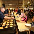 Capt. Willie Watts with the Fayetteville Fire Department, left, serves pancakes to Skyler Autry, 10,...