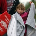Mary Audra Baledge, 7, of Springdale tries to stay warm while walking Saturday morning to Reynolds R...