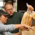 Volunteer Kay Scott from Kay’s Kitchen and Rick Boosey loaded a bag with food for a family of five a...
