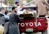 Pakistani police officers push a vehicle carrying an injured person after a suicide bombing in Shangla, Pakistan, on Monday.