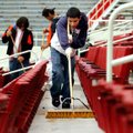 Jose Hernandez, 15, sweeps Sunday along a row of seats on the south side of Reynolds Razorback Stadi...