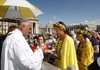 Pilgrims from Hawaii, in yellow clothes with floral patterns, take Holy Communion during a canonization ceremony in St. Peter’s Square, led by Pope Benedict XVI at the Vatican Sunday.