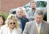 Following his attorneys, Elizabeth and Joel Huggins, and with his wife, Nola, at his side, Roger Barrett, center, entered Circuit Judge David Clinger’s courtroom in Bentonville on Monday. 

