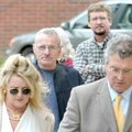 Following his attorneys, Elizabeth and Joel Huggins, and with his wife, Nola, at his side, Roger Bar...