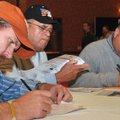 Franklin Blecher, left, Benigno Santiago and his son Benjamin, all of Rogers, filled out job applica...