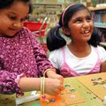 Anushka Jadhav, 4, left, and Arthi Krishna, 7, both of Bentonville, glued glitter and gems on the di...