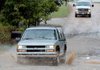 The driver of a sport utility vehicle bounced and splashed its way through the ruts and puddles on Elk Road in Cave Springs on Tuesday. 

