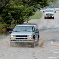 The driver of a sport utility vehicle bounced and splashed its way through the ruts and puddles on E...