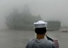 Richard Schimberg watches the USS New York sail through heavy fog Tuesday on the Mississippi River in New Orleans.