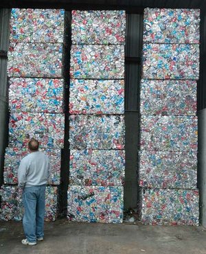 Washington County Justice of the Peace Steve Zega looks at stacks of aluminum cans Wednesday during a tour of Fayetteville’s Solid Waste and Recycling Facility. Elected officials from Benton, Madison and Washington counties toured a variety of solid waste facilities to exchange ideas.