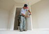 Robert Head installs doorknobs Thursday in a new house at 11 Bonnard Cove in Maumelle.