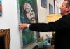 Faron Smith, the owner of Ideas Antique and Modern Decor in downtown Bentonville, put up a painting in his newly  opened antique shop. 