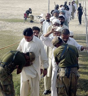 Pakistani soldiers check people who fled from fighting in South Waziristan as they arrive Monday in the town of Dera Ismail Khan, Pakistan.