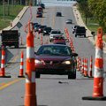 Traffic on west New Hope Road in Rogers is diverted as workers from Hutchens Asphalt Paving repair a...