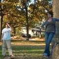 Nick Davidson watches as Samantha Seal walks on a slack line Tuesday at Wilson Park in Fayetteville....