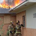 Rogers rookie firefighters Nick Ardemagni (left) and Jerrett Coffelt break some windows during a liv...