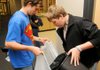 Rogers High School senior Steven Boak, left, and junior Dustin Sims collected office waste for recycling in the school’s main office on Thursday.