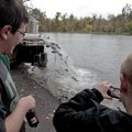 Hugh Smith (left) and Jay Eubanks, both 13, watch Friday as Arkansas Game and Fish Commission worker...