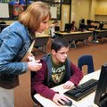 Sixth-grade math teacher Karen Bradshaw helped Kyle Davison, 11,  of Rogers sign in to a program dur...