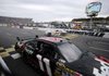 Denny Hamlin crosses the finish line Sunday to win the NASCAR Sprint Cup TUMS Fast Relief 500 as John Andretti’s car spins out.
