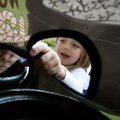 Cicely Verzani, 4, of Bella Vista reaches her hand through a hole in a curtain to feel some of the “...