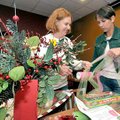 Nancy Evans, left, and Sara Herlevic with the Junior Auxiliary of Rogers-Bentonville wrapped posters...