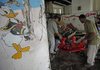 Security guards remove debris Tuesday at a day-care center damaged by a bomb Sunday near the Justice Ministry in Baghdad.