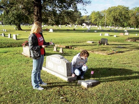 russellville-high-school-seniors-grace-kellner-left-and-talley-gale-right-place-flags-on-a-grave-in-oakland-cemetery-to-show-that-its-information-has-been-collected-the-students-were-gathering-the-data-as-part-of-a-mortality-rate-study-comparing-pre-1950-mortality-rates-to-modern-ones