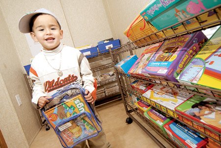 tritian-gutierrez-finds-a-backpack-of-educational-games-and-activities-for-his-mother-to-check-out-at-the-hippy-preschool-parent-center-at-eastside-elementary-school-in-greenbrier