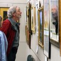 Mel and Darlene O’Connor of Rogers look over artwork Friday at a display by the Rogers Art Guild at ...