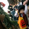 Joey Dorsett, 3, of Rogers holds the hand of his father, David, while looking at the piece of candy ...